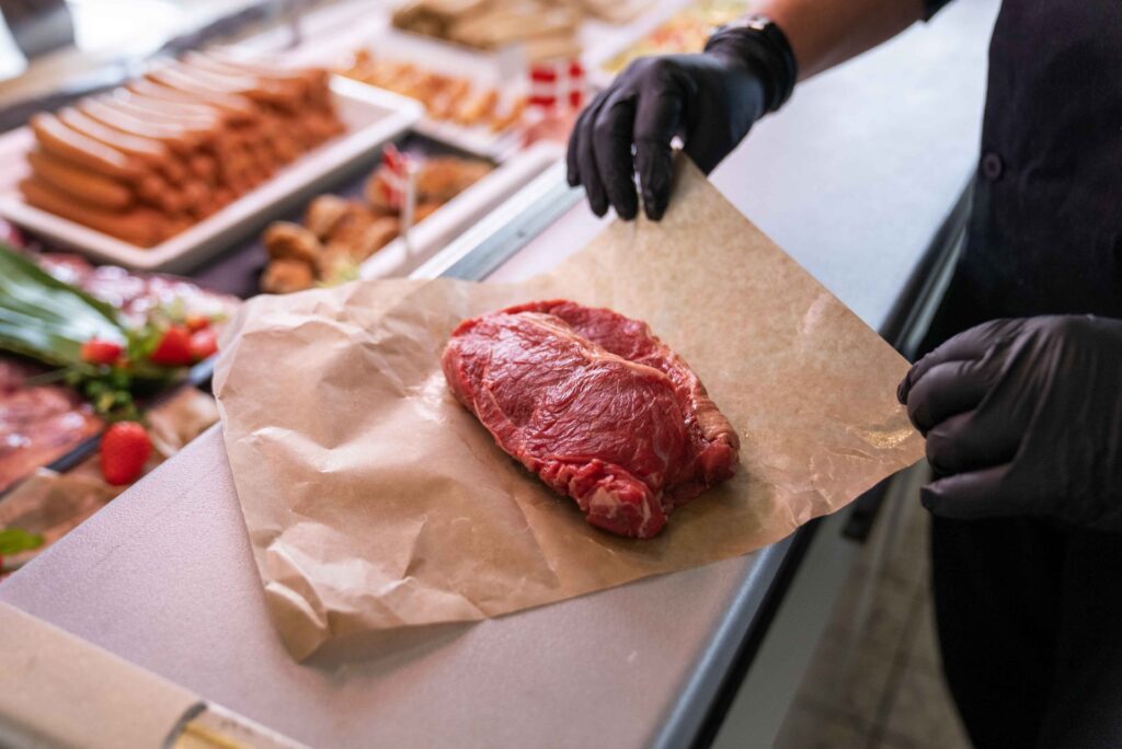 Frisk bøf pakkes ind i slagterpapir ved køledisk.